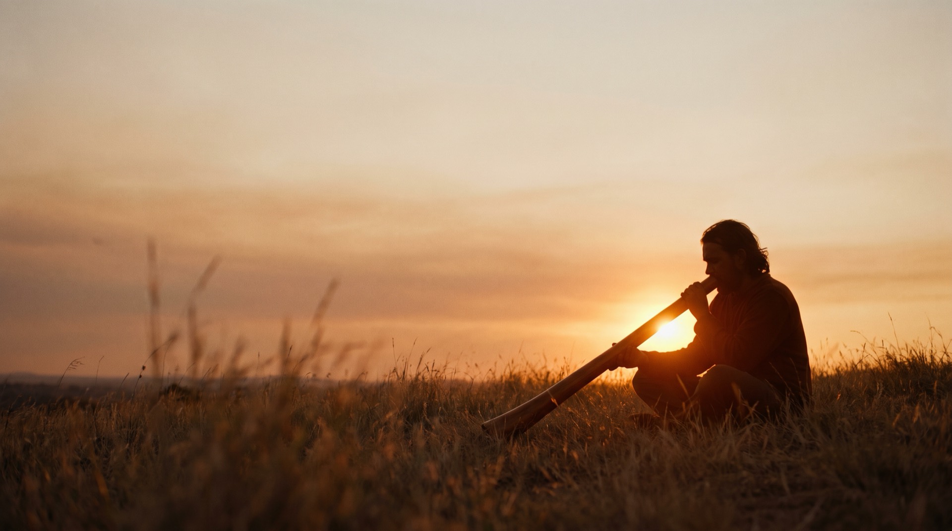 Joueur de didgeridoo au coucher du soleil